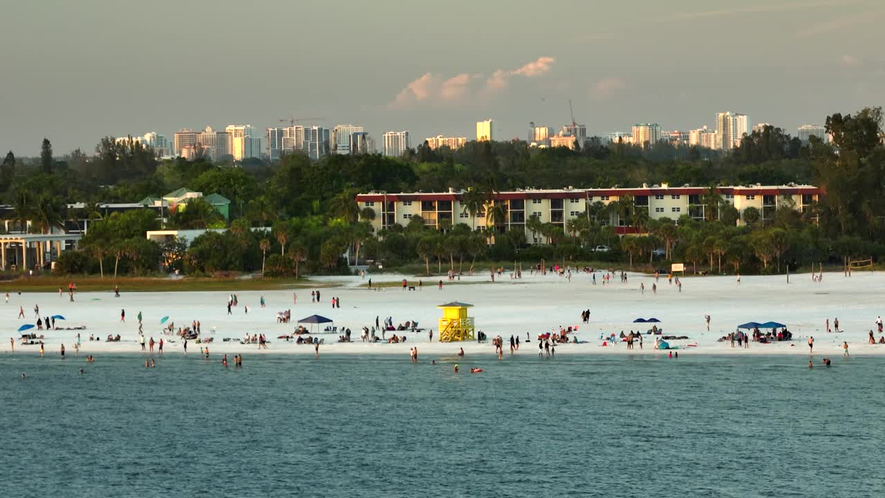 美国萨拉索塔的西斯塔岛沙滩的空中黄昏海景。许多游客喜欢在墨西哥海湾温暖的海水中游泳，在佛罗里达炎热的阳光下晒日光浴视频素材