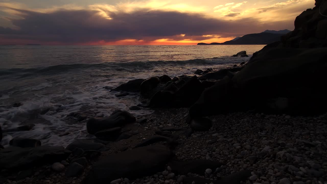 戏剧性的地中海浪漫:日落的橙色黄昏描绘天空和海面-一个迷人的沿海夜晚视频素材