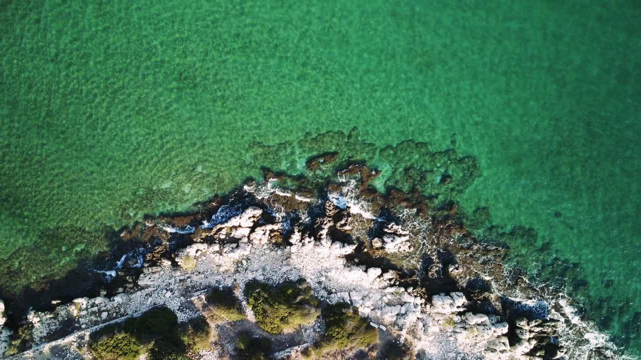 悬崖的鸟瞰图在岩石海滩上缓慢地走向大海。4k无人机视频。视频素材