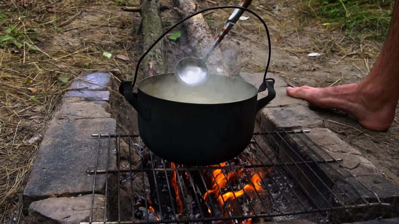 土豆在白天用大锅在明火上煮视频素材