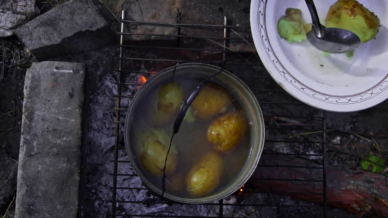 土豆在白天用大锅在明火上煮视频素材