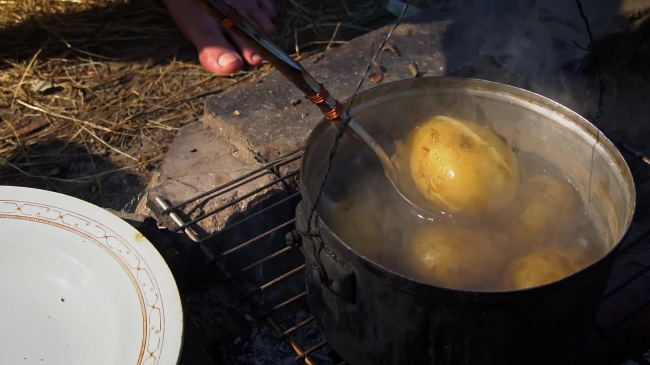 土豆在白天用大锅在明火上煮视频素材