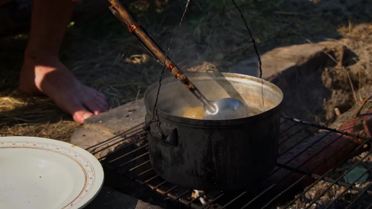 土豆在白天用大锅在明火上煮视频素材