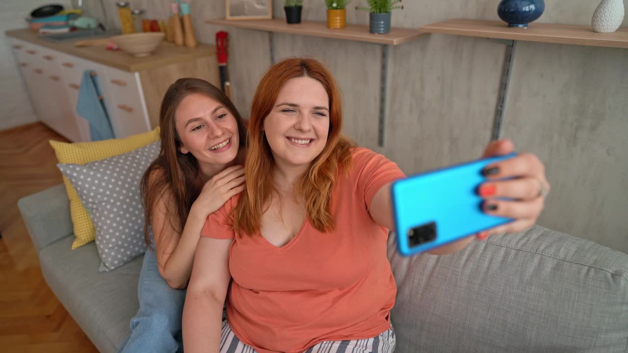 两个女性朋友在沙发上自拍视频素材
