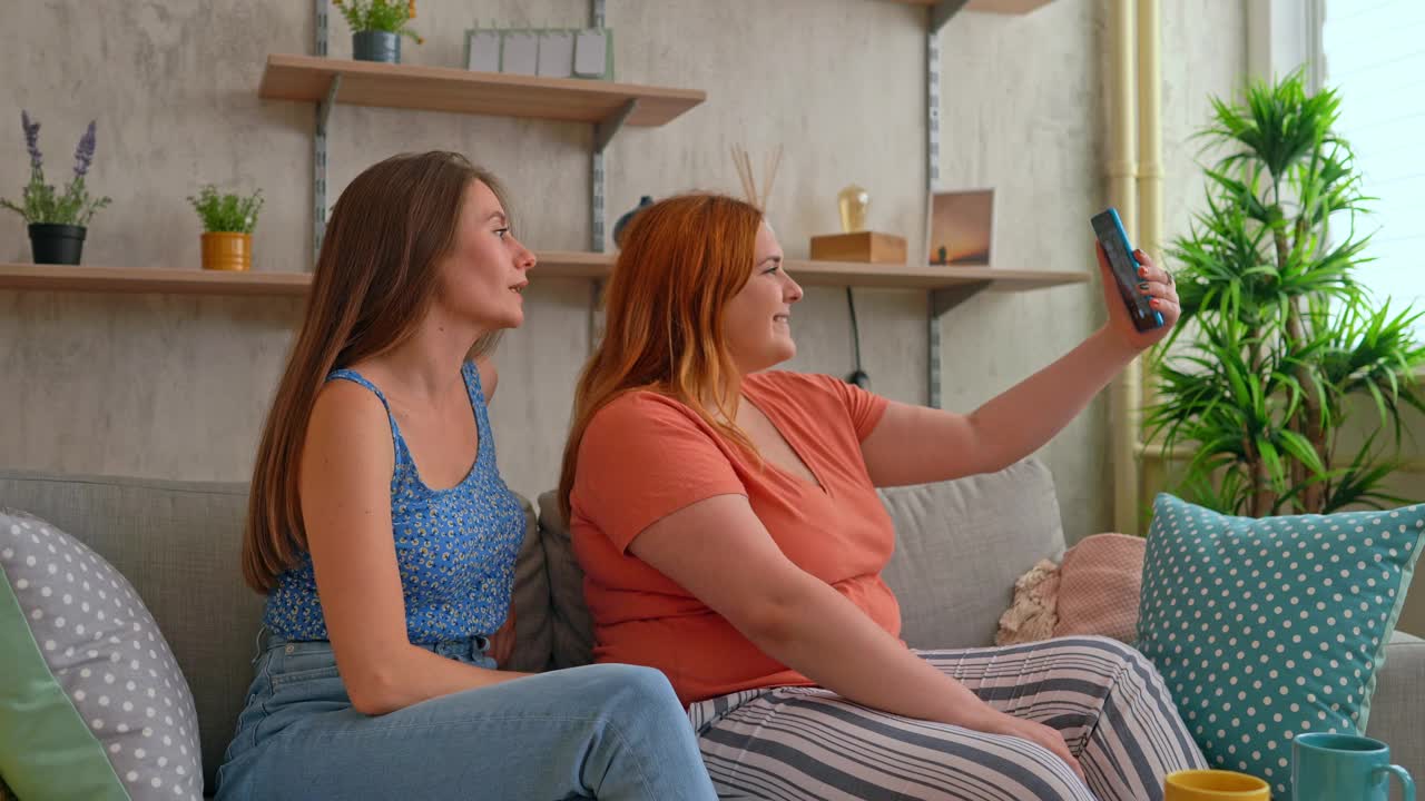 两个女性朋友在沙发上视频通话视频素材