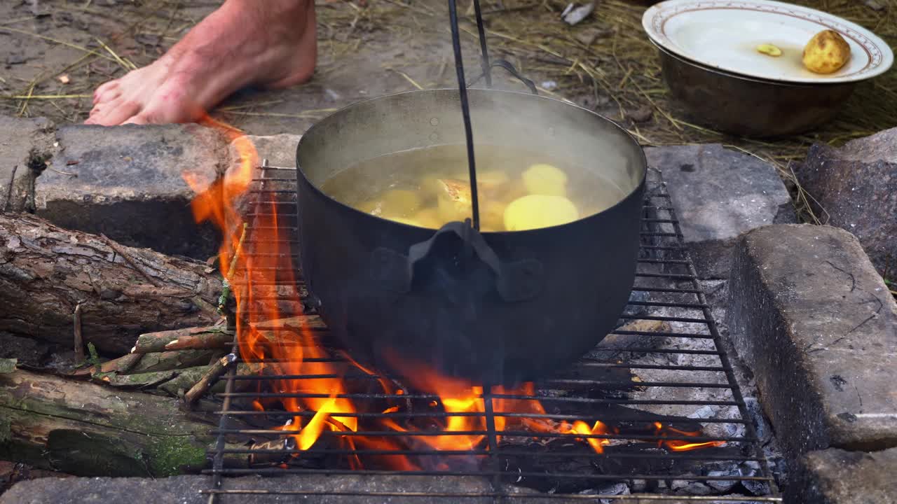 土豆在白天用大锅在明火上煮视频素材