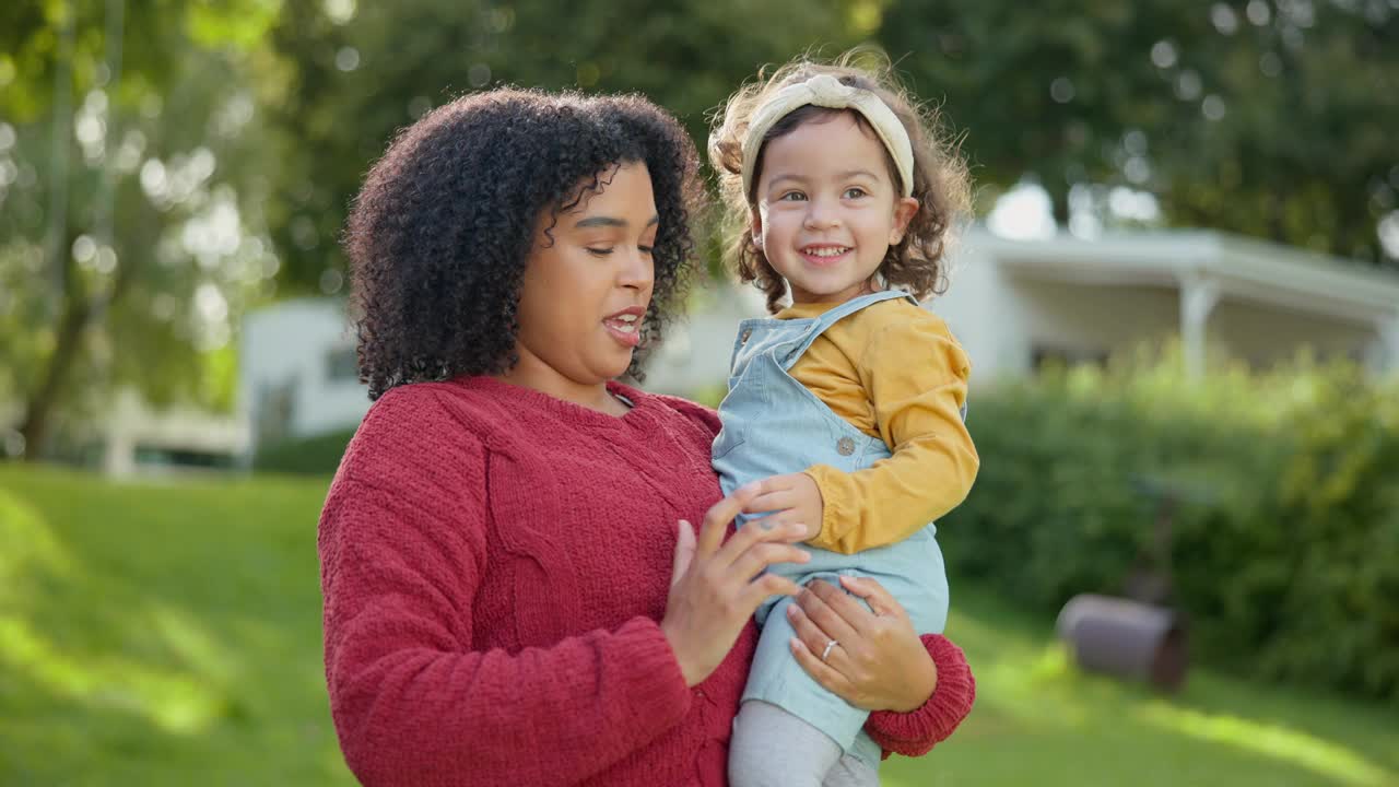 家庭，孩子和一位母亲和她的养女一起在他们寄养家庭的花园里。爱，微笑和孩子与继母抱着她的女孩子在户外的家后院视频素材