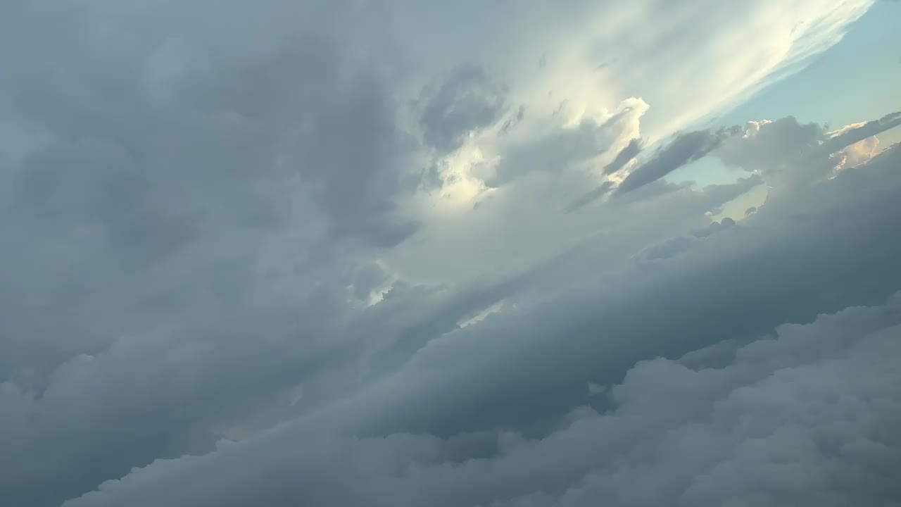 在8000米高空右转时，飞行员看到飞机飞过暴风雨的天空。在日落时分。一个飞行员的视角。视频素材