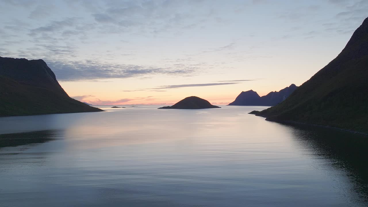 美丽的黄色和蓝色日落在田园诗般的海水和山的剪影，空中视频素材