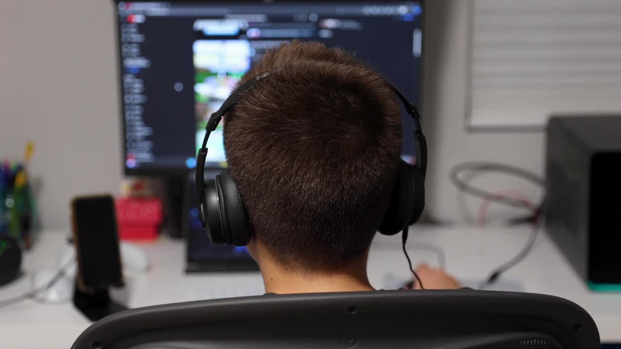 小男孩坐在他房间里的电脑前视频素材