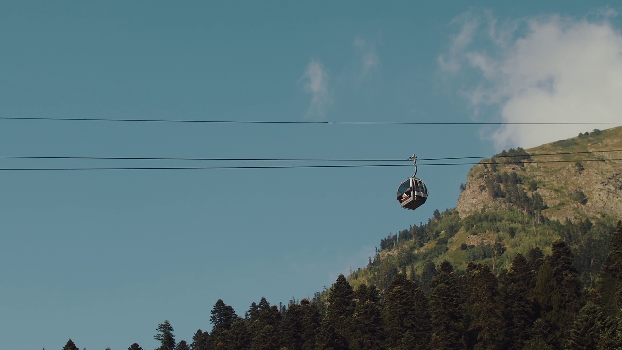 以山、针叶树和蓝天为背景的缆车视频素材