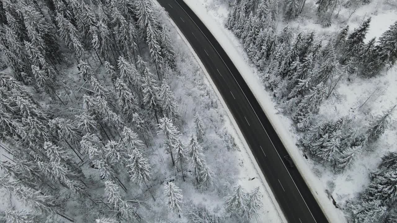 在芬兰的雪林中，汽车正行驶在被雪覆盖的道路上视频素材