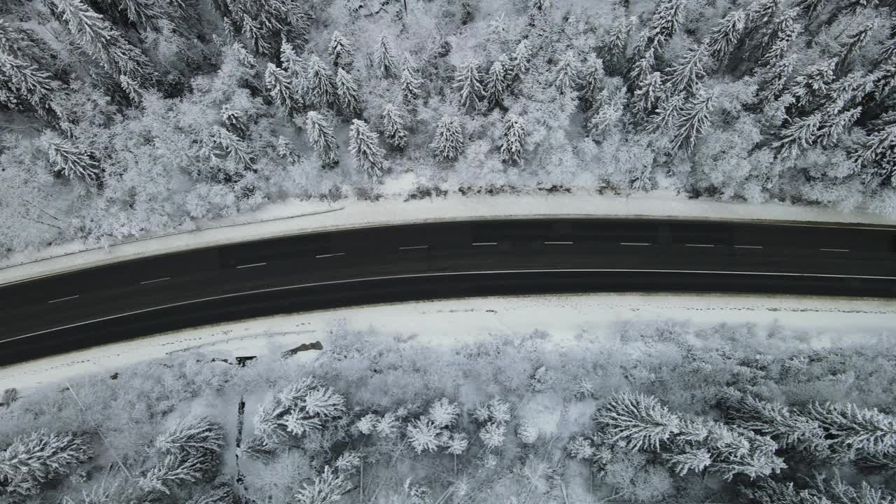 在芬兰的雪林中，汽车正行驶在被雪覆盖的道路上视频素材