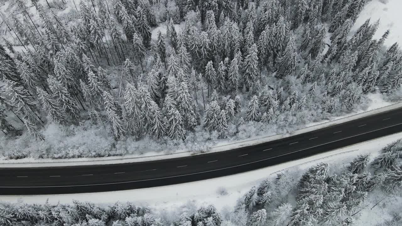 在芬兰的雪林中，汽车正行驶在被雪覆盖的道路上视频素材