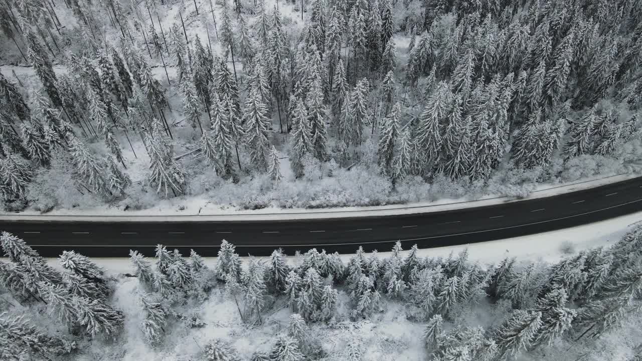 在芬兰的雪林中，汽车正行驶在被雪覆盖的道路上视频素材