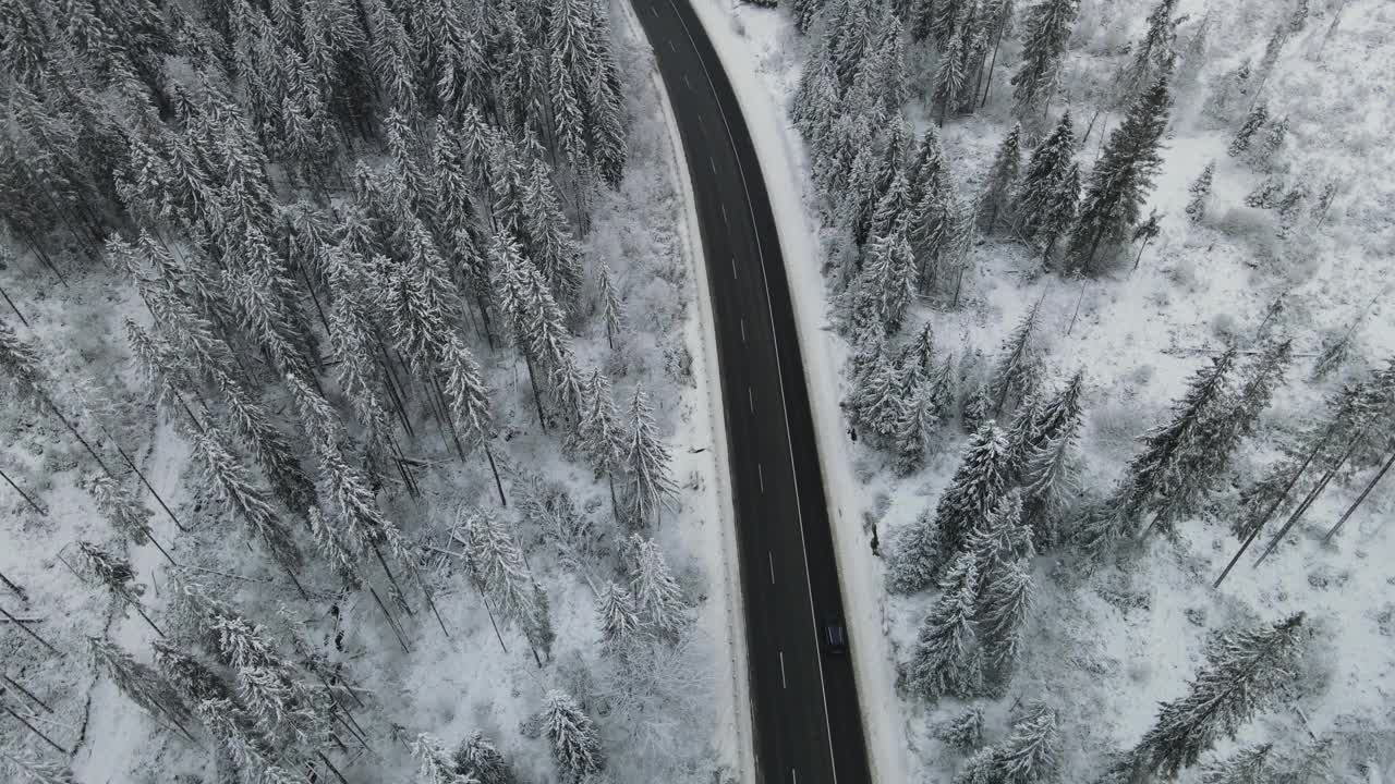 在芬兰的雪林中，汽车正行驶在被雪覆盖的道路上视频素材