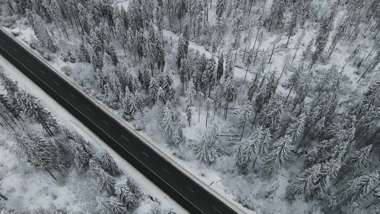 在芬兰的雪林中，汽车正行驶在被雪覆盖的道路上视频素材