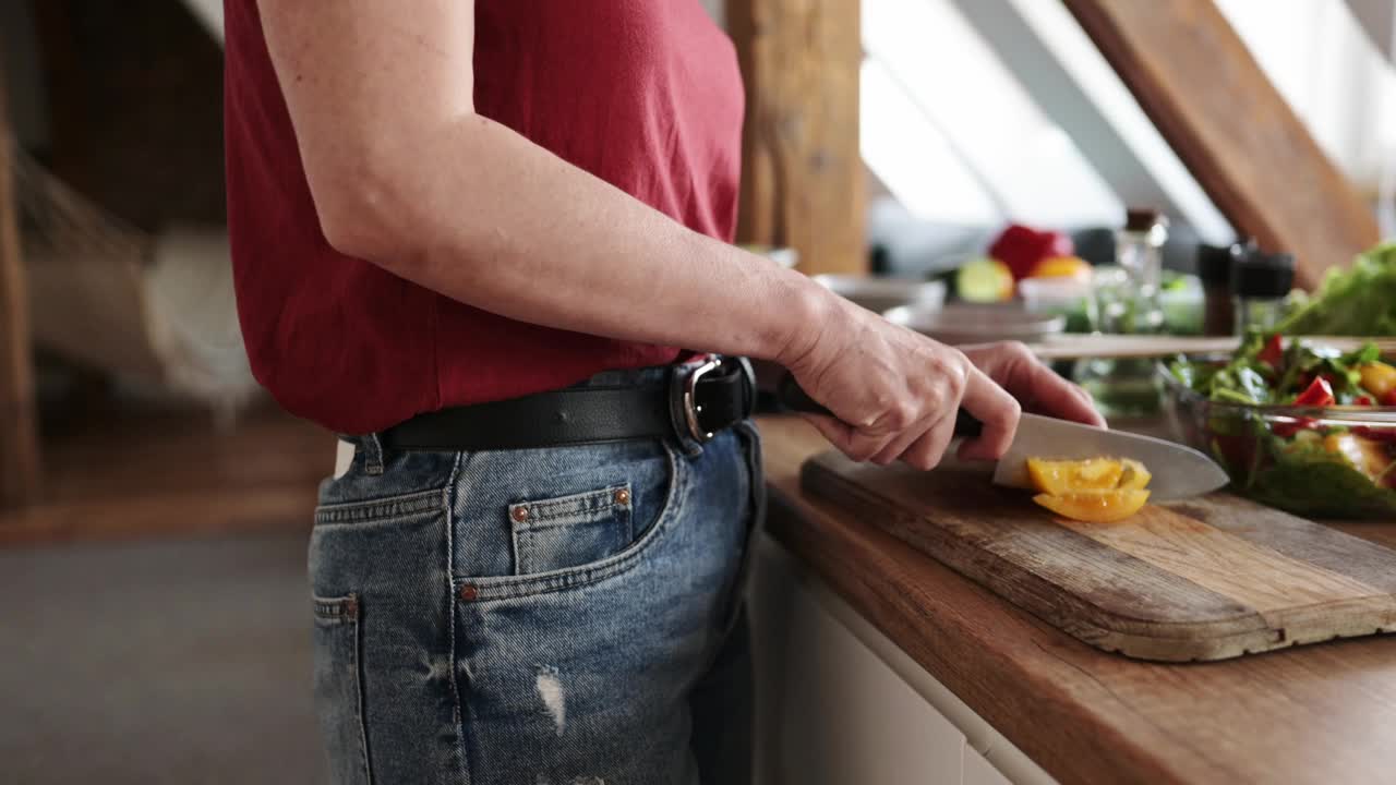 一个女人正在切菜板上切沙拉用的蔬菜视频素材