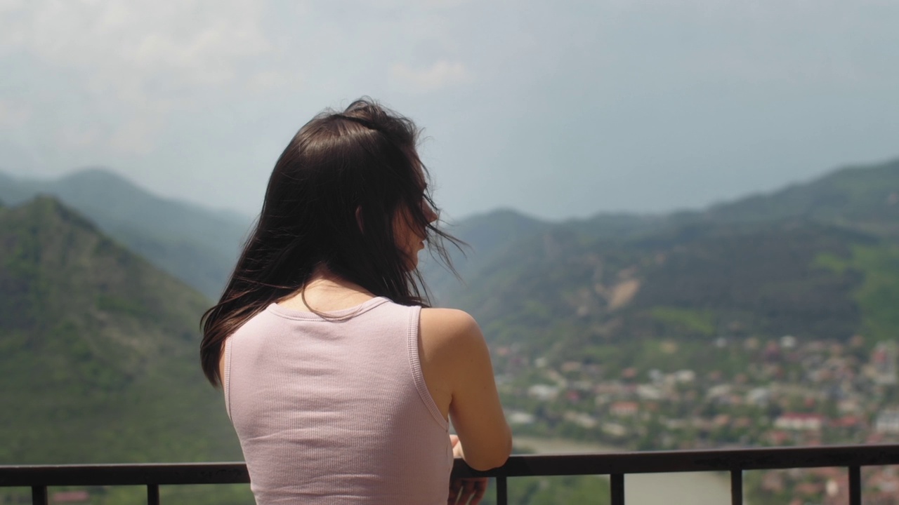 在观景台上看城市风景的女人。年轻的黑发女性从视角欣赏城市风景。旅游及旅游概念视频下载