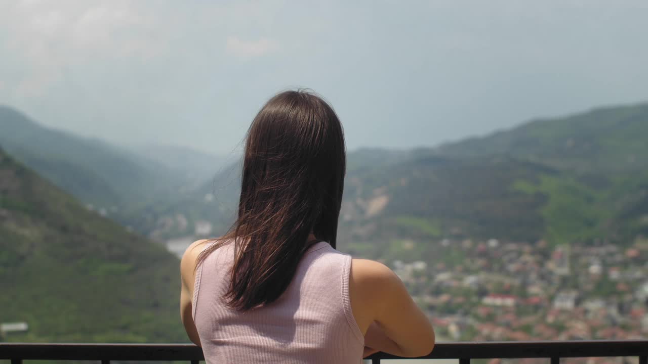 在观景台上看城市风景的女人。年轻的黑发女性从视角欣赏城市风景。旅游及旅游概念视频下载