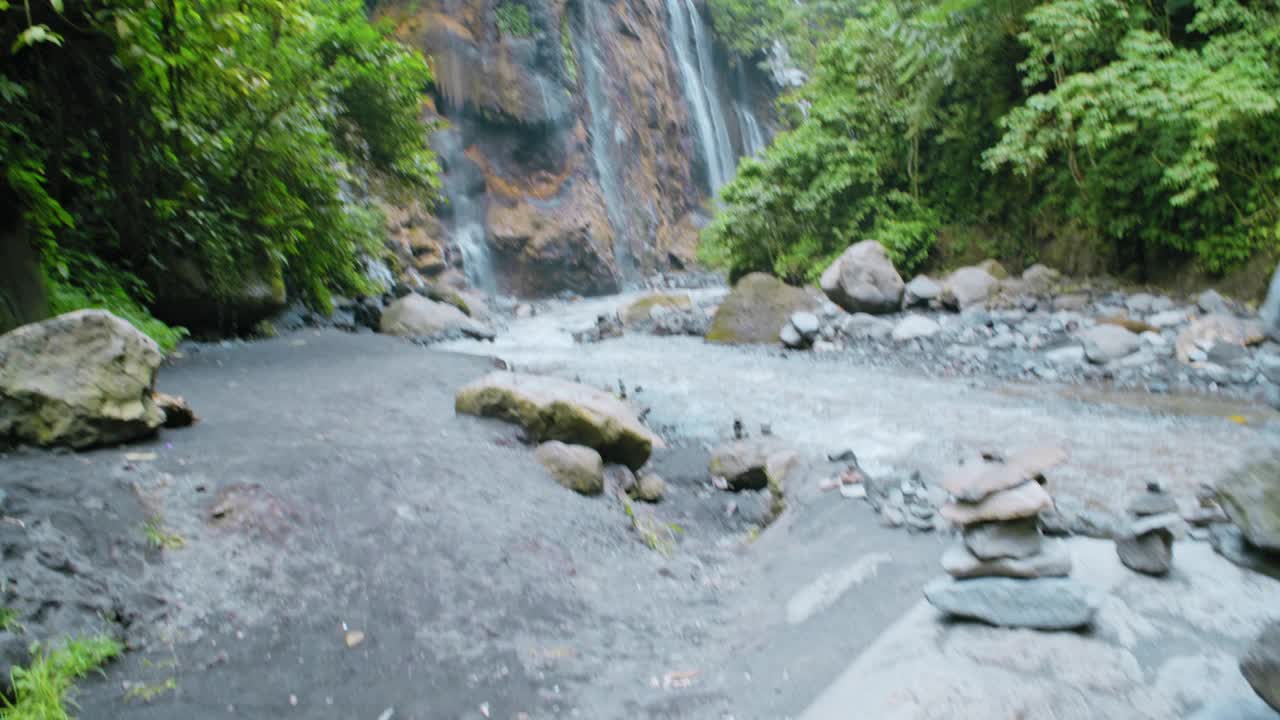 在印度尼西亚的热带丛林峡谷。目前山上清澈见底的水覆着绿油油的热带雨林。视频素材