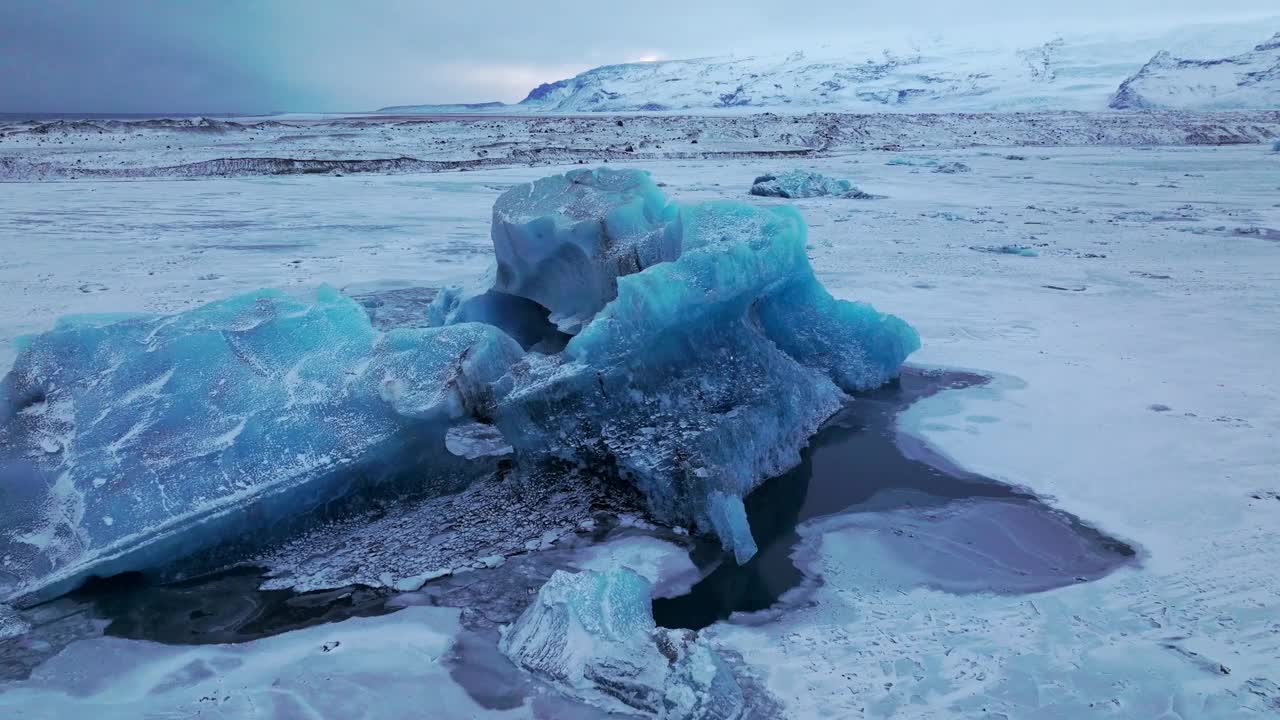 在冰岛，黄昏时，在冰冻的Jokulsarlón湖面上的冰山鸟瞰视频素材