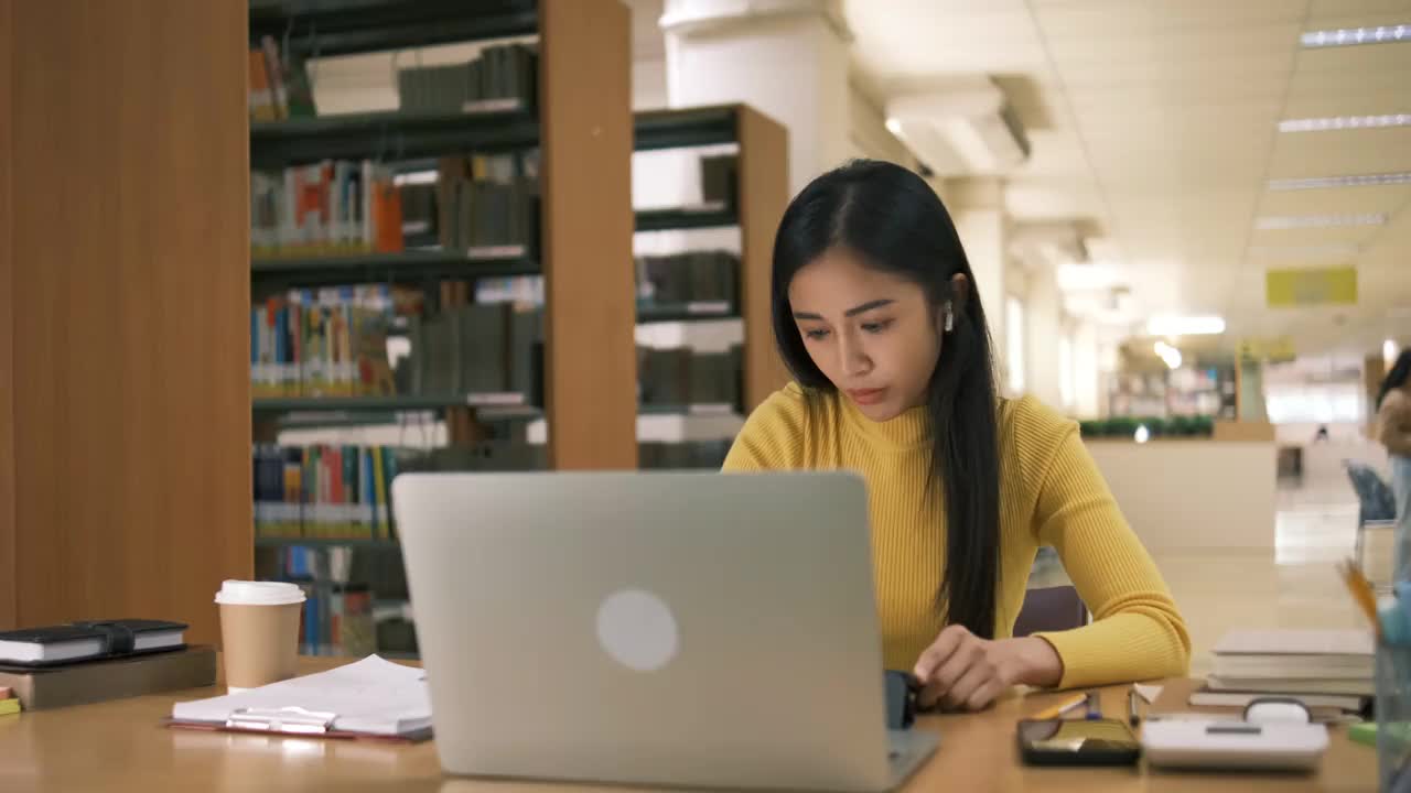 亚洲女孩在线学习课堂学习在线视频呼叫zoom老师，快乐亚洲女孩在线学习英语笔记本电脑。视频素材