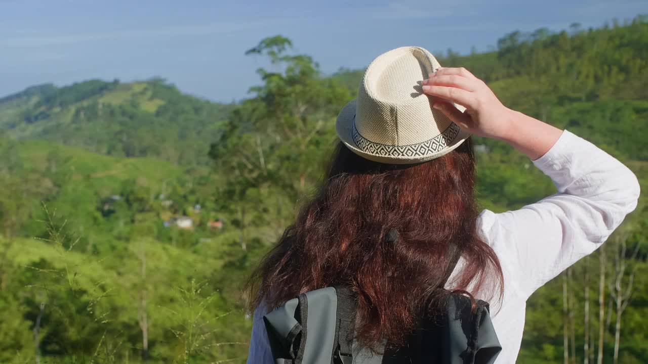 夏天戴着帽子欣赏绿色风景的妇女视频素材