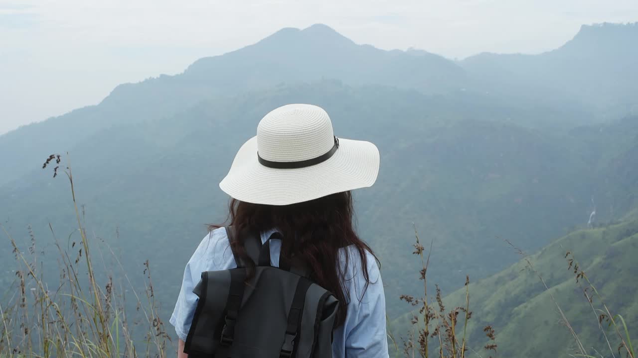 度假时戴着帽子看山的女人视频素材