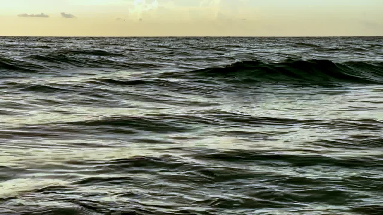 日出时海浪的慢镜头。视频素材