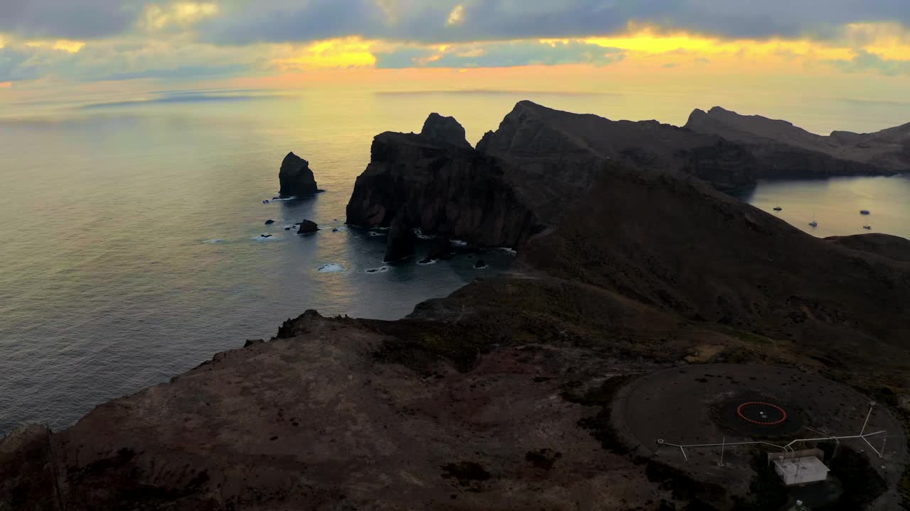 AERIAL Drone shot of Rugged Mountainous Coastline in Madeira under Orange Cloudy Sky at Sunset视频素材