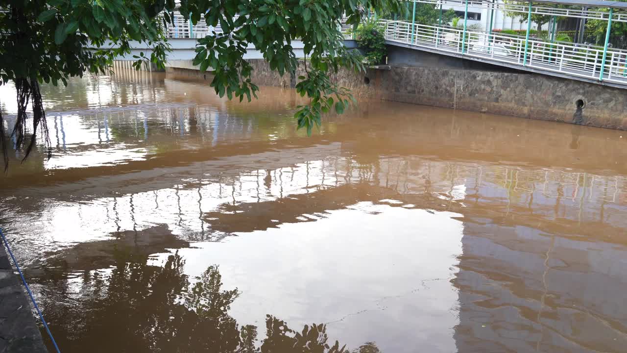 印度尼西亚雅加达的一条河流，河水浑浊肮脏，呈棕色视频下载