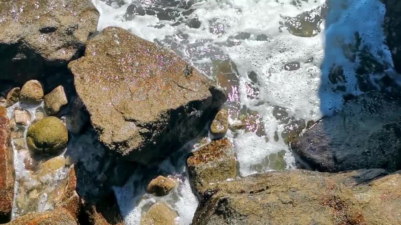 冲浪浪蓝绿色的水岩石悬崖巨石埃斯孔迪多港。视频素材