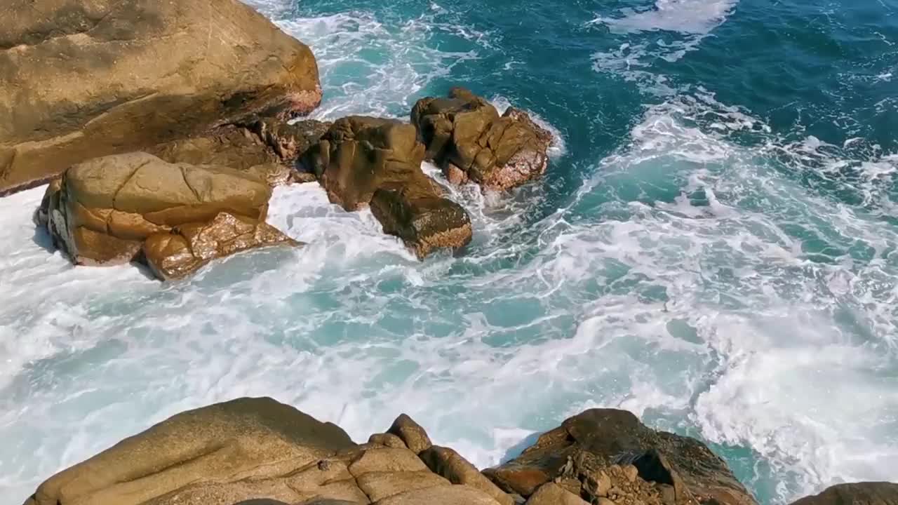 冲浪浪蓝绿色的水岩石悬崖巨石埃斯孔迪多港。视频素材