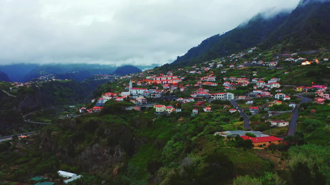 空中无人机拍摄的美丽小镇在多云的天空下马德拉岛的山地景观视频素材