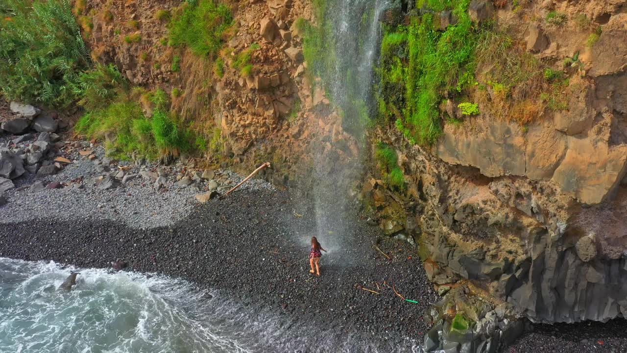 空中无人机拍摄的女游客在瀑布下从落基山在马德拉岛视频素材