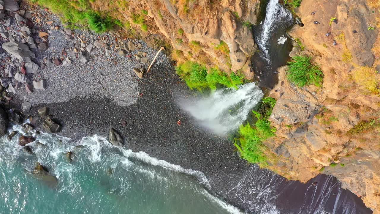 航拍的女游客欣赏壮观的瀑布从落基山附近的海在马德拉岛视频素材