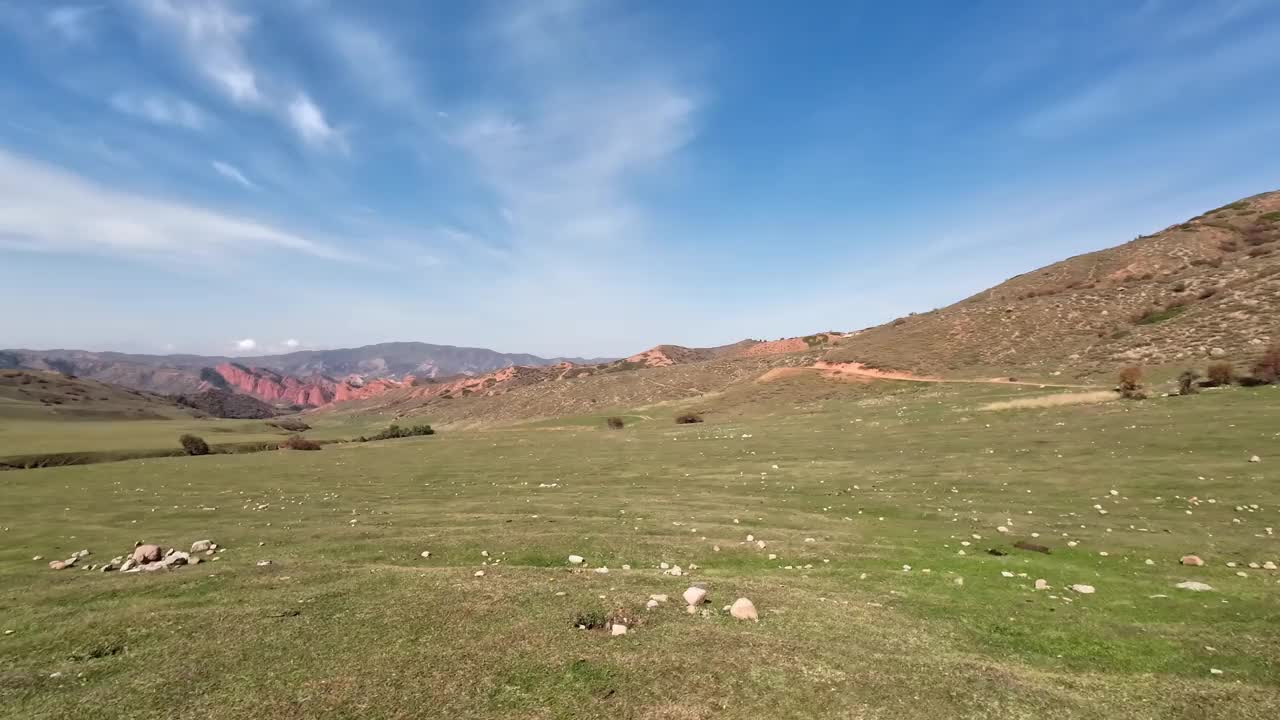 绿色山谷的广角镜头，背景是红色的岩石和雪山视频素材