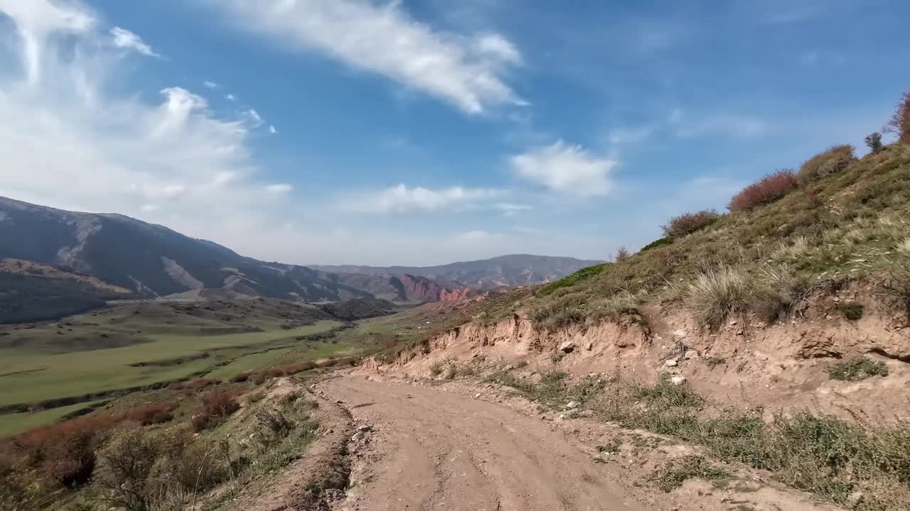 移动到绿色山谷的泥土和岩石山路视频素材