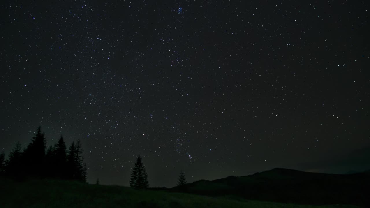 移动的云和星星在夜空中越过山脉的时间流逝视频素材