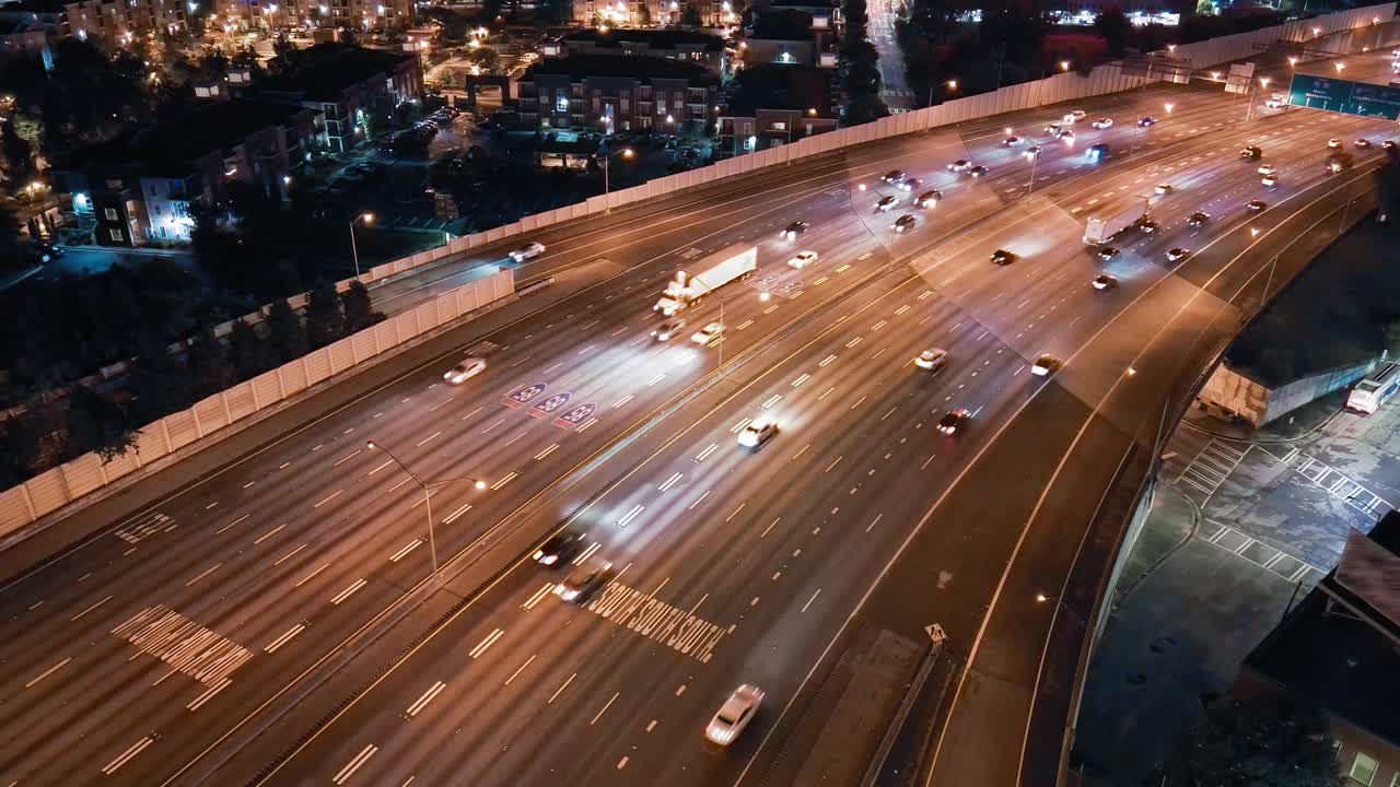 夜间照明的高速公路动脉:夜间高架道路上繁忙的交通。亚特兰大市中心连接器，GA。航空镜头与静态相机运动视频素材