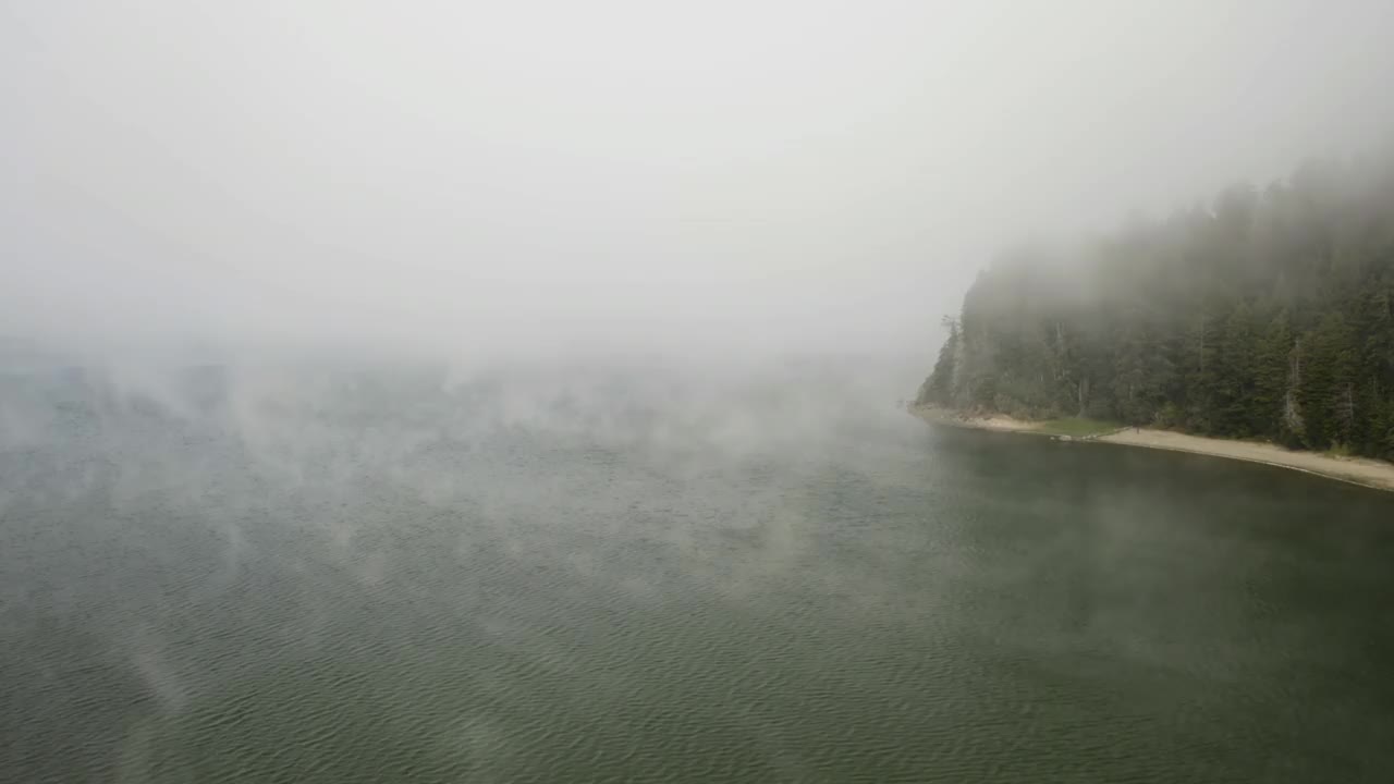 从空中俯瞰雾蒙蒙的水面，经过湖岸和湖滩，在美国视频素材