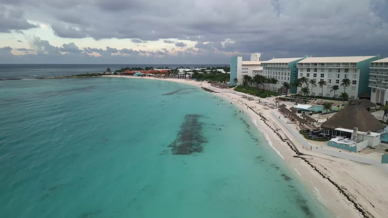 美丽的坎昆海滩与清澈的蓝色海水沿着海岸海滨与酒店和度假村俯瞰海洋。墨西哥度假和暑假旅游胜地。视频素材