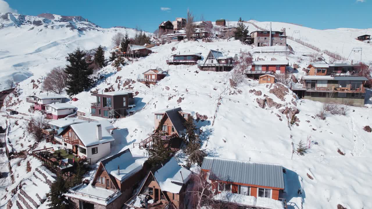 在智利圣地亚哥附近的Farellones滑雪胜地，俯瞰白雪覆盖的小木屋。空中拍摄视频素材