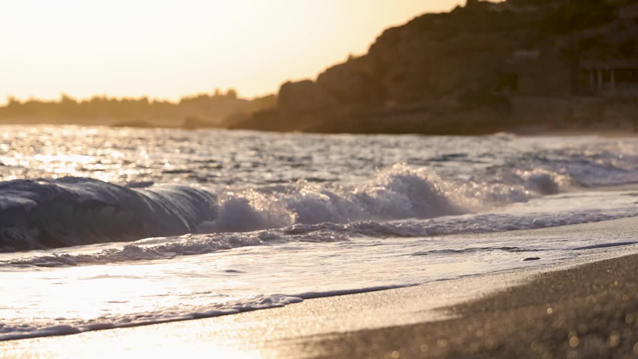 日落时分，美丽的海浪拍打着地中海沙滩上的沙滩视频素材