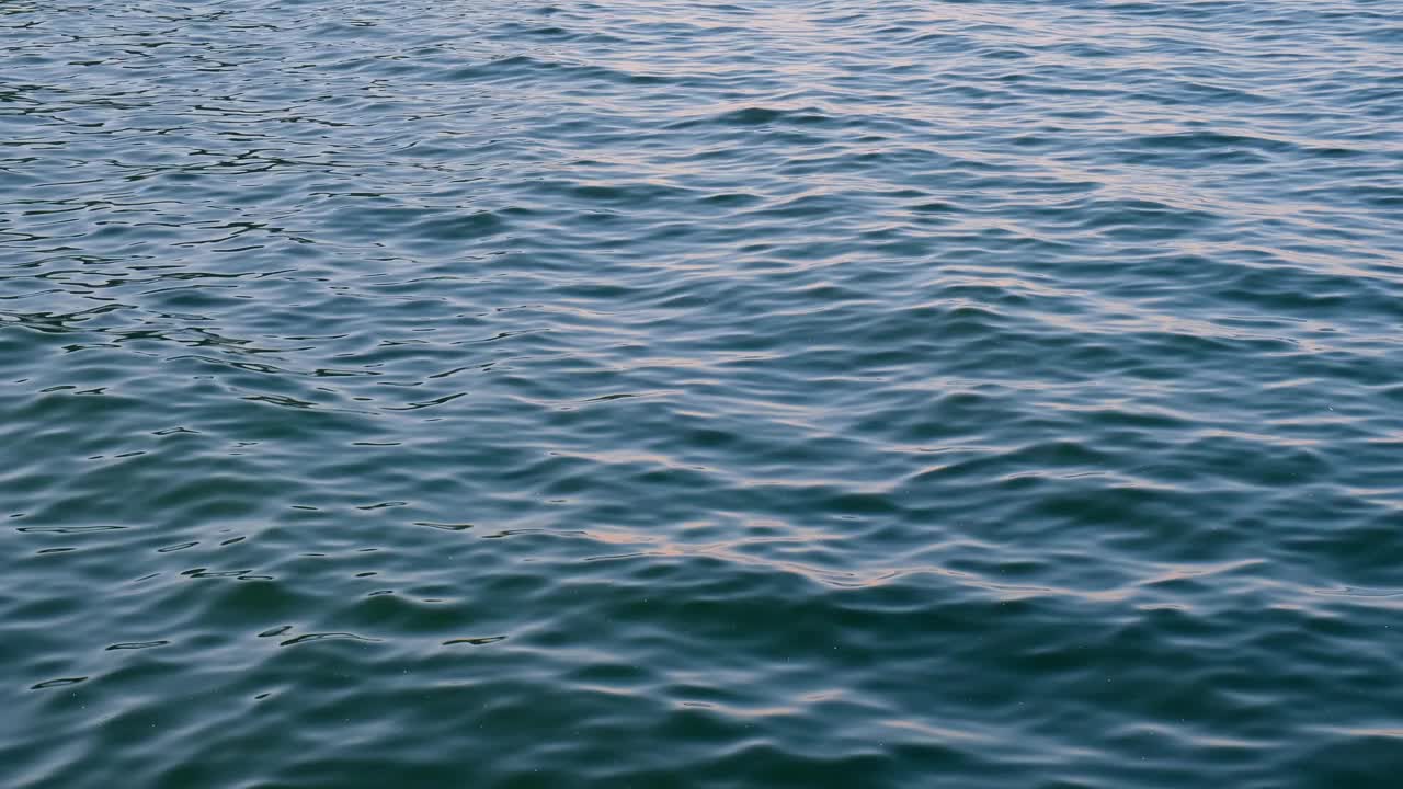 波罗的海深蓝色的云和海或海洋水面与泡沫波浪暴风雨前，戏剧性的海景背景日落。抽象图案纹理。视频素材