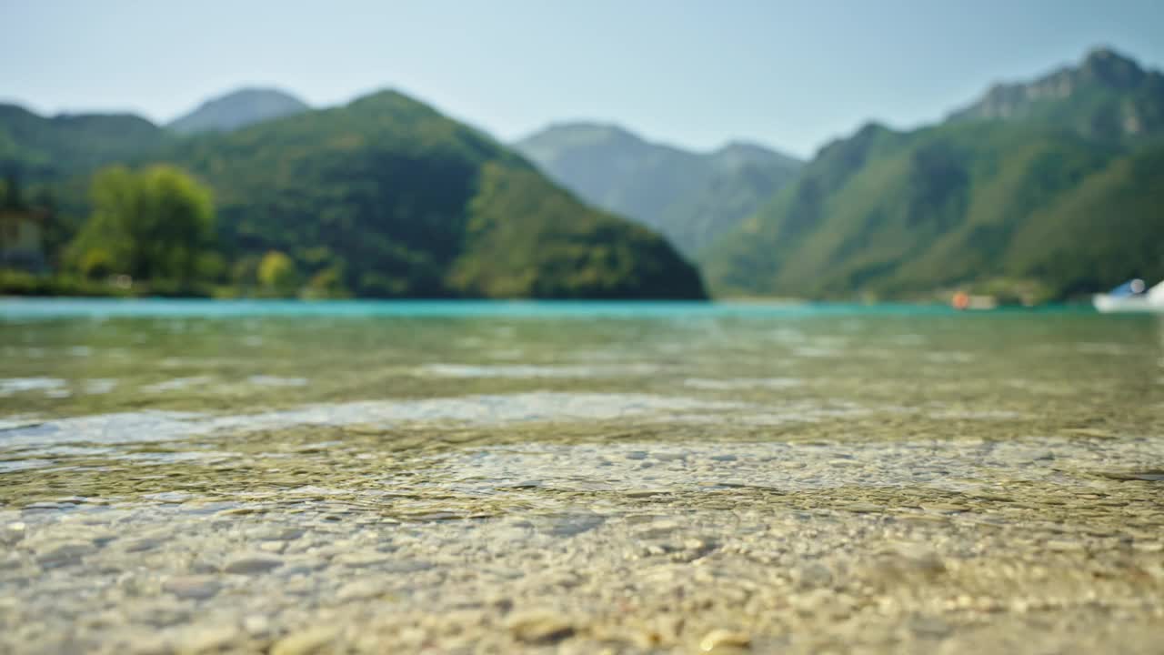 在晴朗的日子里，清澈的加尔达湖与雄伟的山脉视频素材