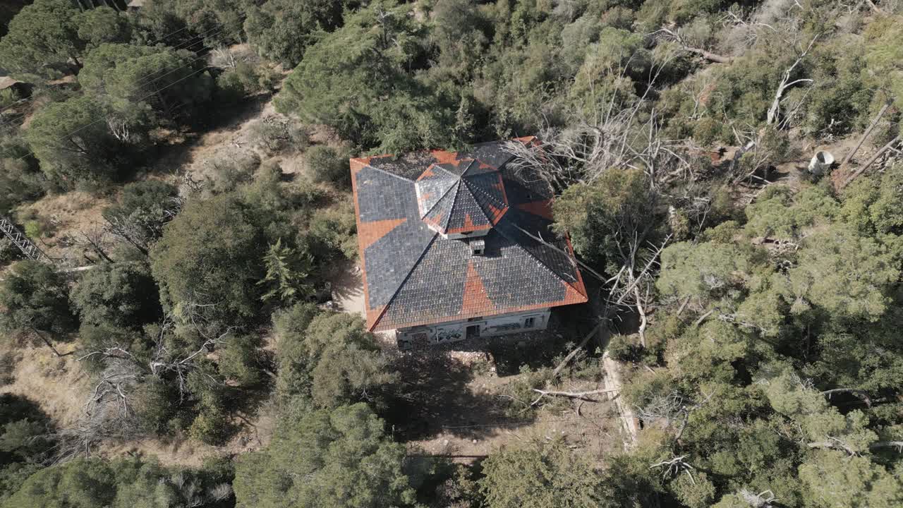 温暖的夏季天气。废弃的建筑孤立地坐落在树林里，空中视频素材