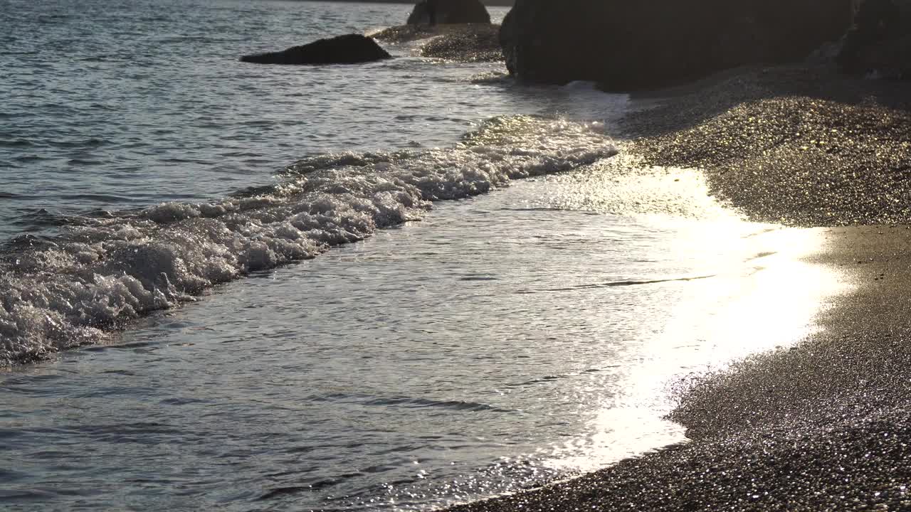 海滩上金色的日落。在温暖的阳光下，泡沫般的海浪向金色的沙滩翻滚。缓慢的运动。没有人。假日休闲概念。抽象航海夏日海洋日落的自然。视频素材