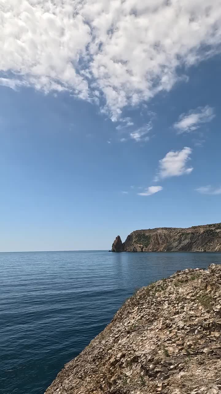 垂直鸟瞰平静蔚蓝的大海和火山岩海岸。小波浪在水面上的运动模糊。自然夏天海洋大海沙滩背景。没有人。度假、度假、旅游的概念视频素材